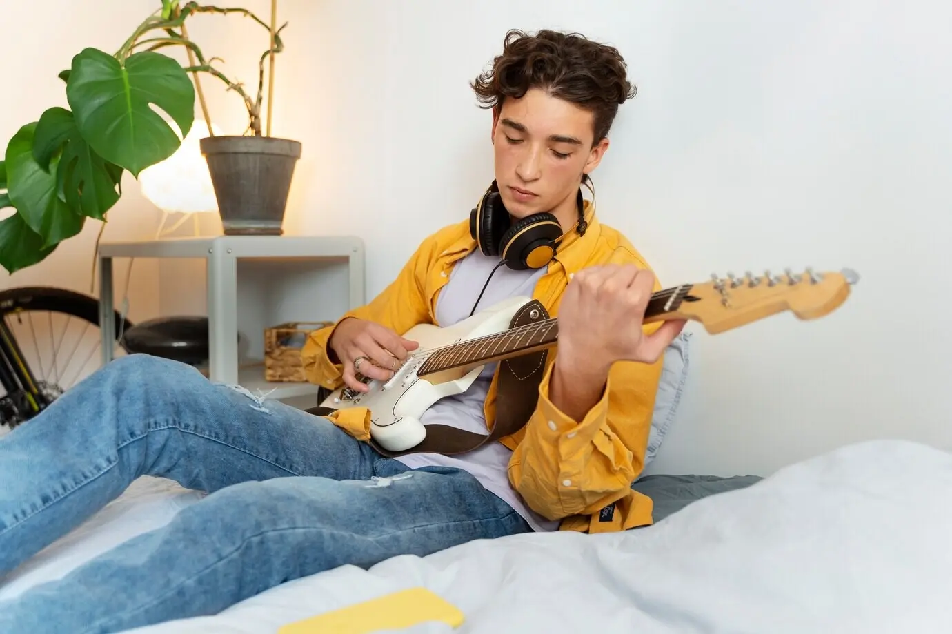 Seitenansicht eines Jungen, der zu Hause Gitarre spielt